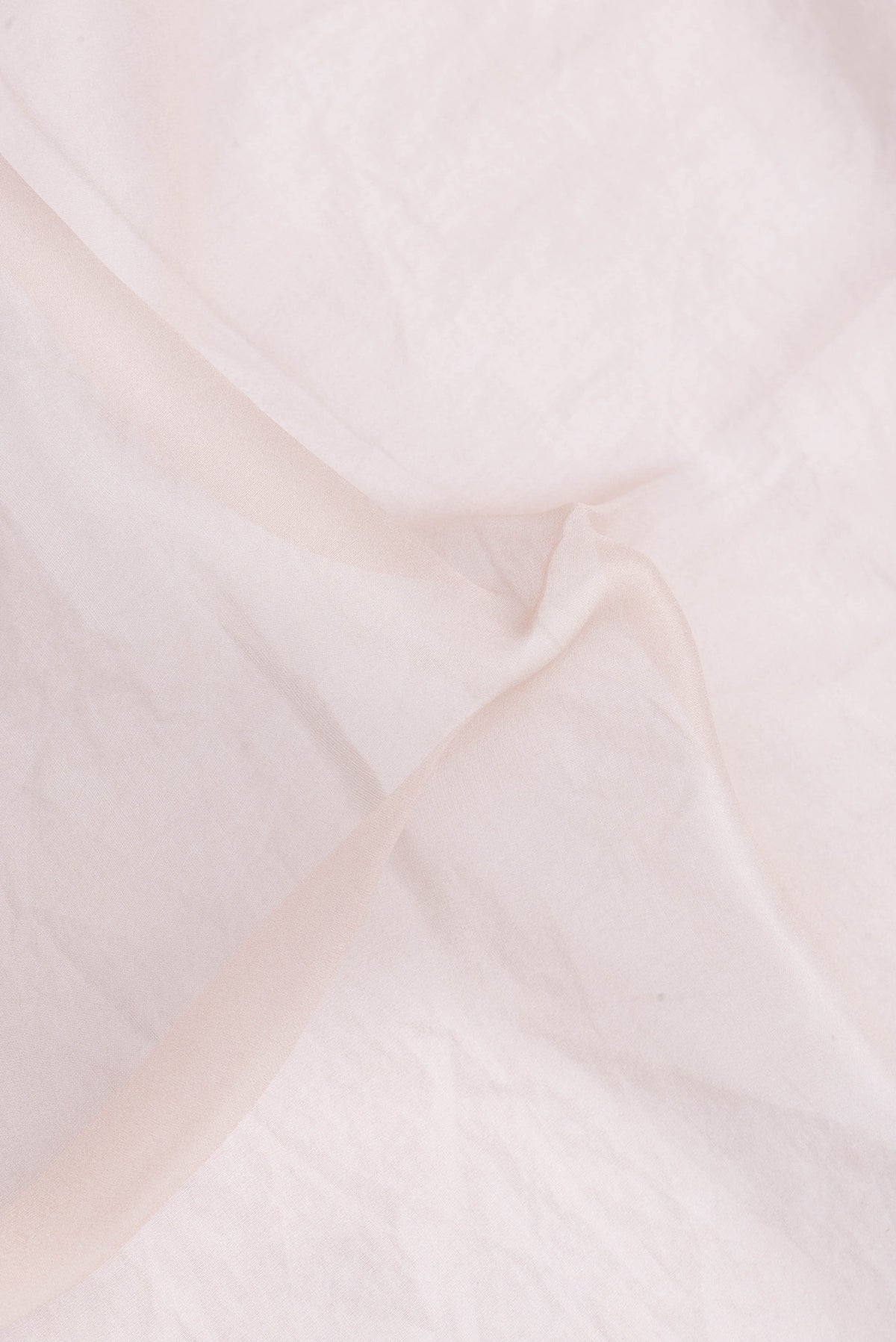 Close up of Rose Gold Dual Tone Organza Silk Saree with Plain Body and Printed Border.  displaying folds