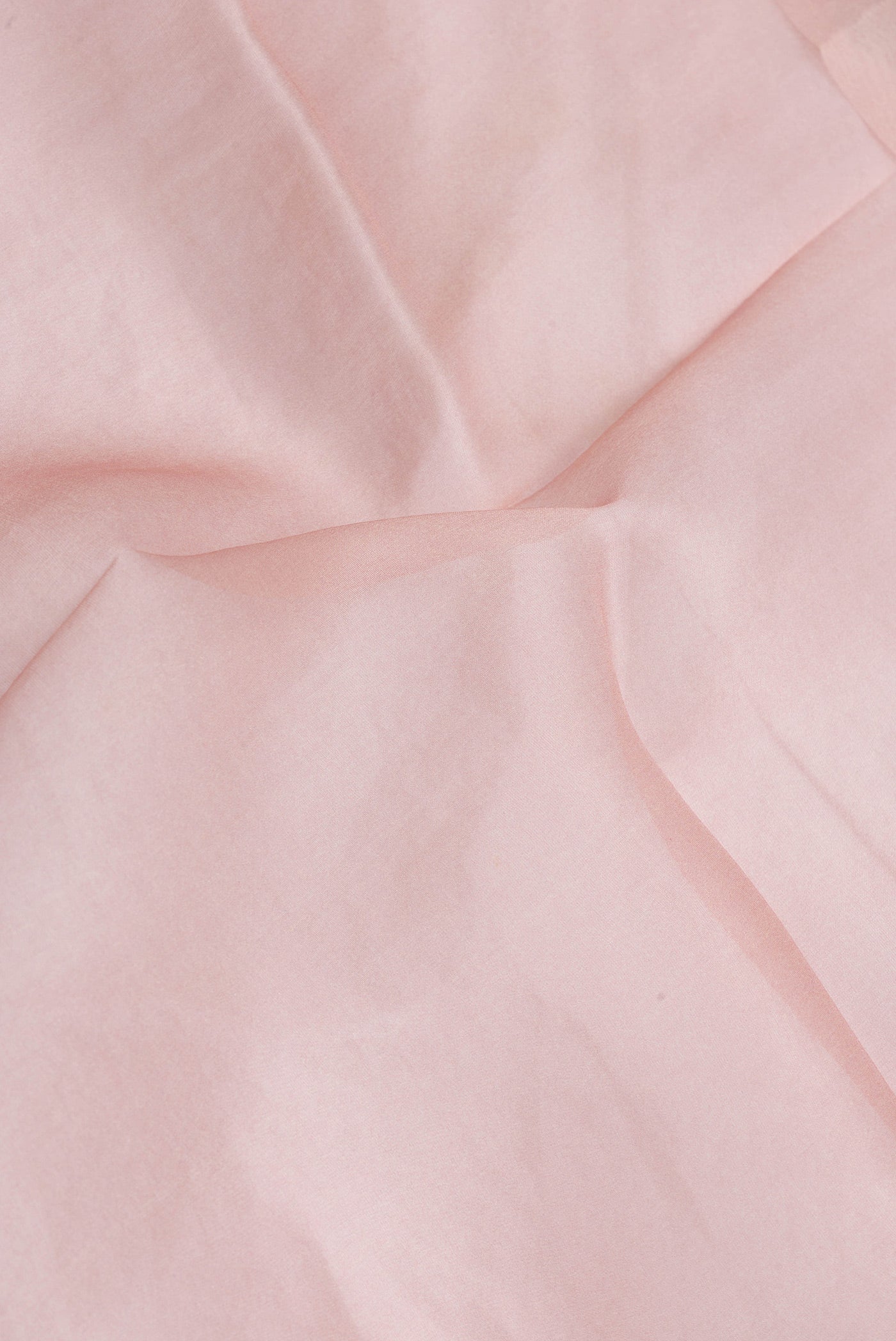 Close up of Rose Gold Dual Tone Organza Silk Saree with Plain Body and Printed Border.  displaying folds