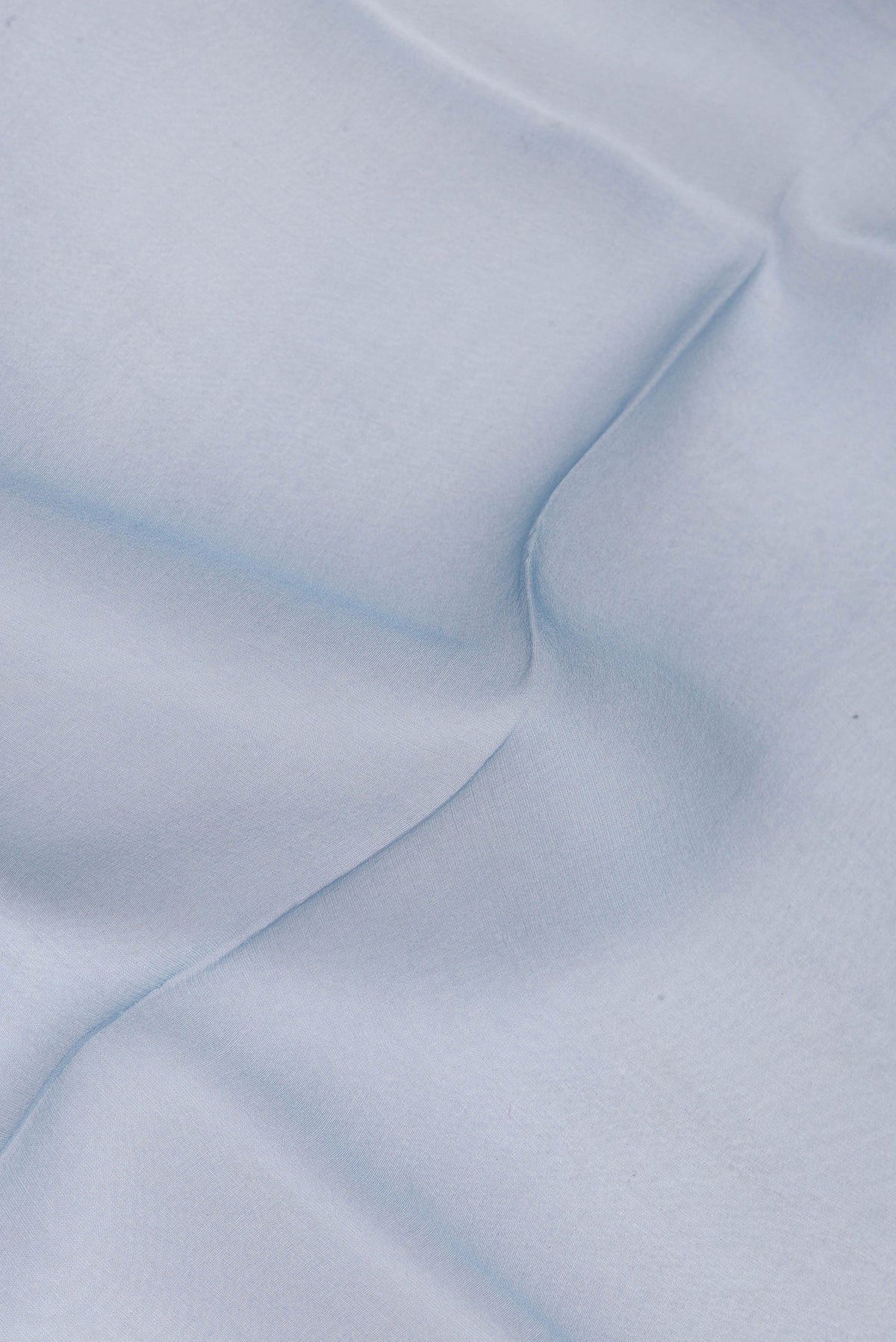 Close up of Blue Organza Silk Saree with Plain Body and Printed Border.  displaying folds