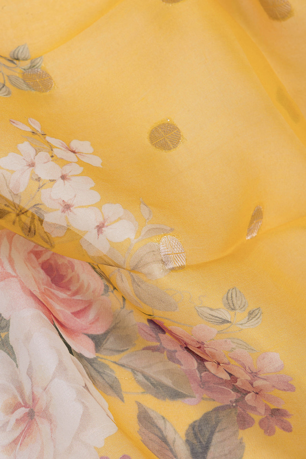 Close up of Yellow Organza Silk Saree with Zari Butta on the body and Fancy Border.  displaying folds