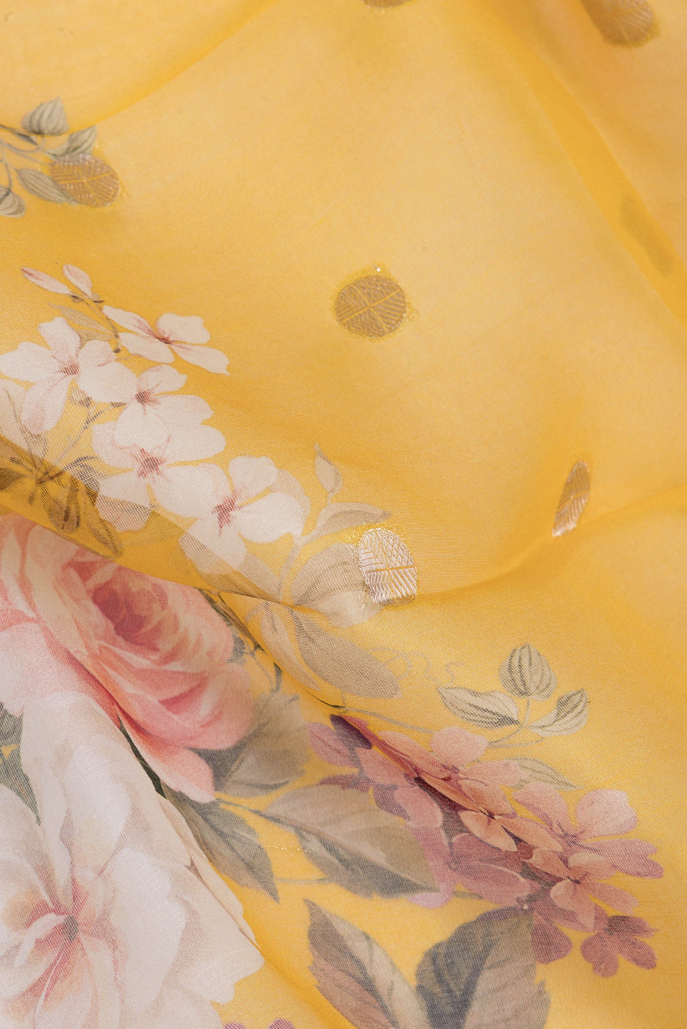 Close up of Yellow Organza Silk Saree with Zari Butta on the body and Fancy Border.  displaying folds