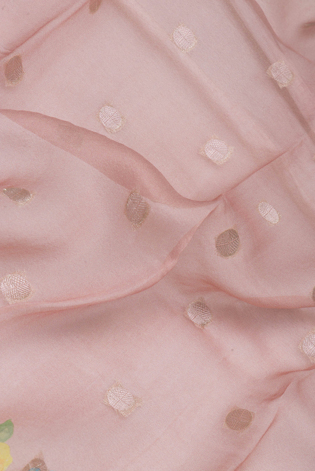 Close up of Rose Gold Organza Silk Saree with Zari Butta on the body and Fancy Border.  displaying folds