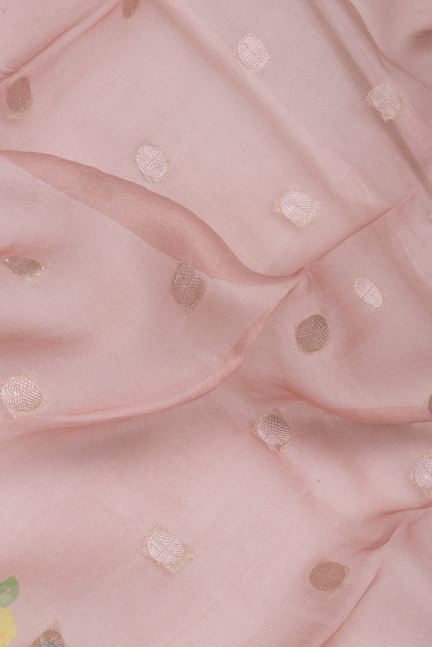 Close up of Rose Gold Organza Silk Saree with Zari Butta on the body and Fancy Border.  displaying folds