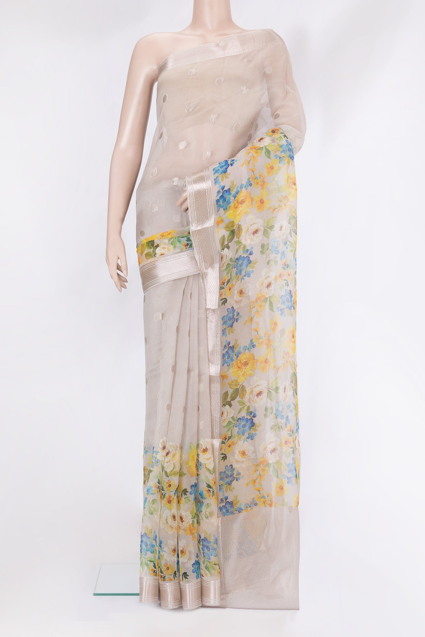 Beige Organza Silk Saree with Zari Butta on the body and Fancy Border.  displayed on a mannequin