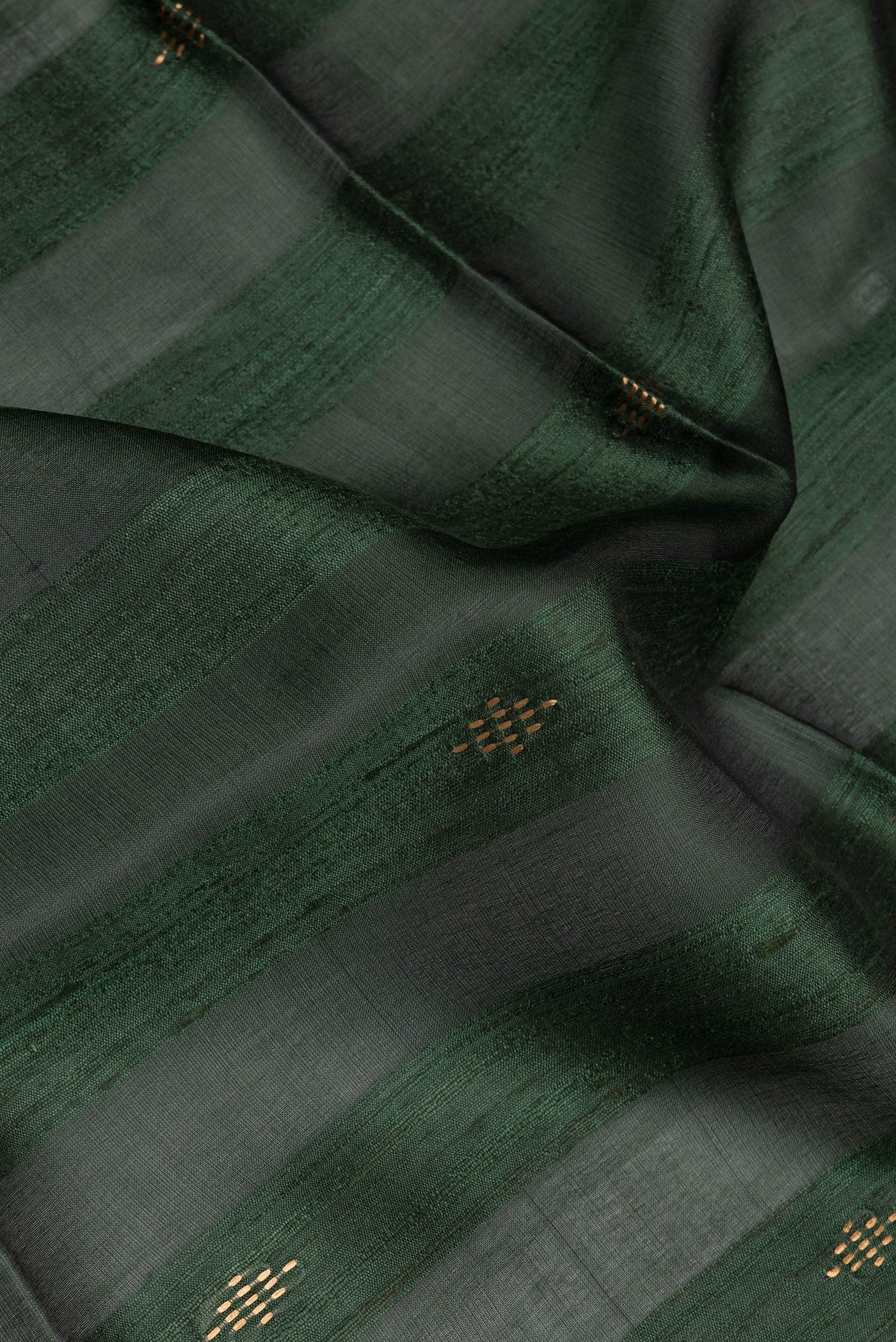 Close up of Olive Green Tussar Silk Saree with Art Illustrations on the body and Zari Border.  displaying folds