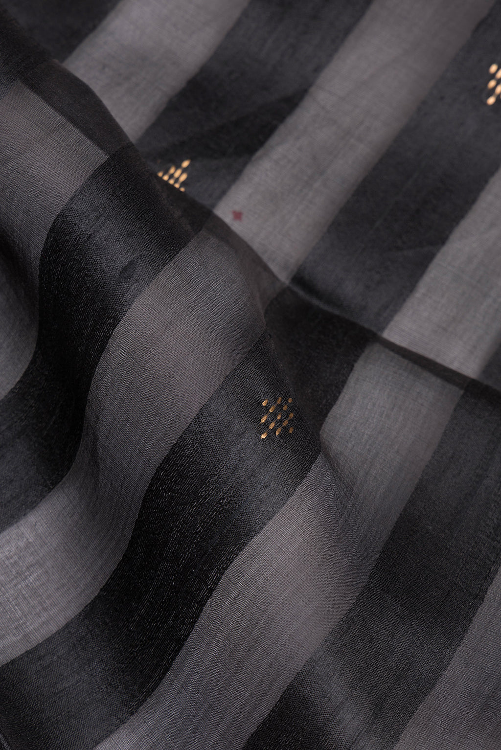 Close up of Black Tussar Silk Saree with Stripes on the body and Zari Border.  displaying folds