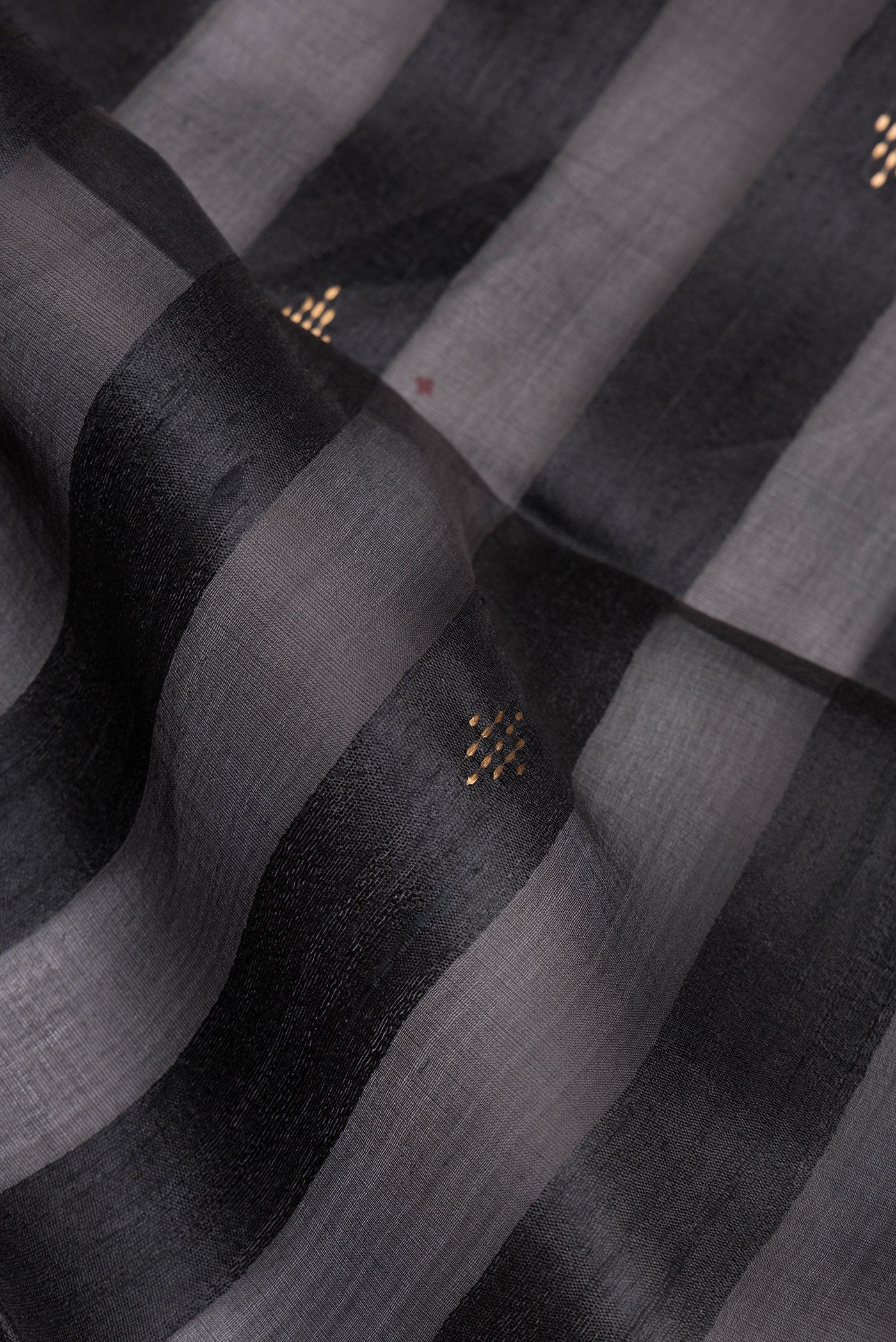 Close up of Black Tussar Silk Saree with Stripes on the body and Zari Border.  displaying folds