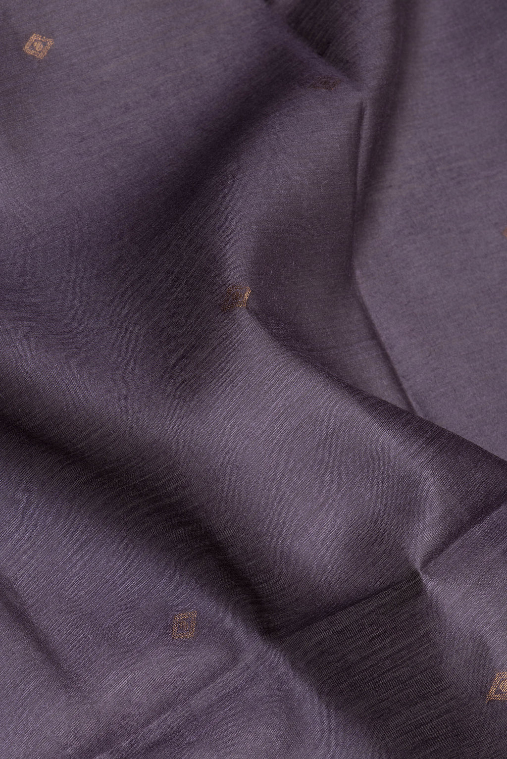 Close up of Purple Tussar Silk Saree with Zari Butta on the body and Ikat Border.  displaying folds