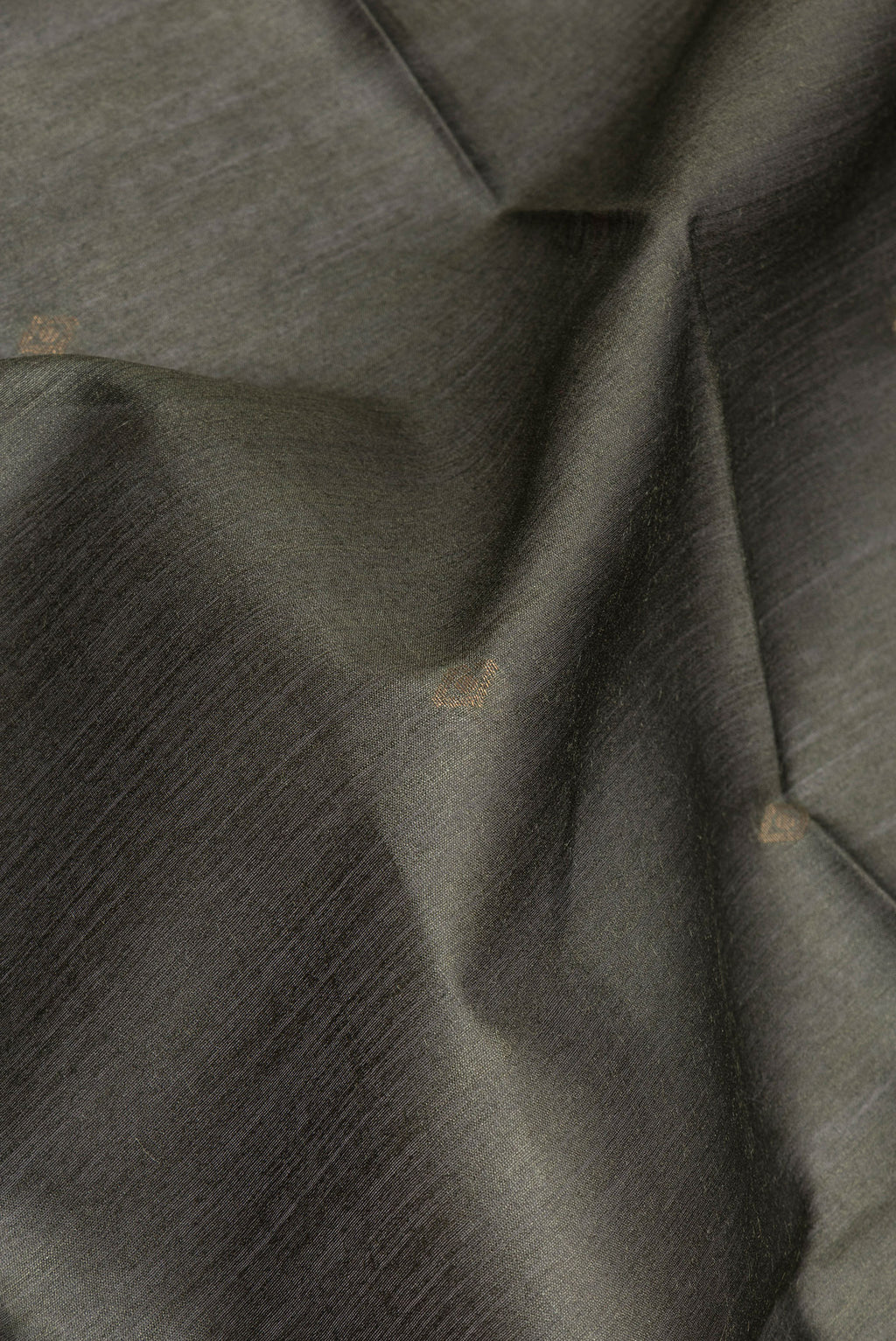 Close up of Mehandi Green Tussar Silk Saree with Zari Butta on the body and Ikat Border.  displaying folds