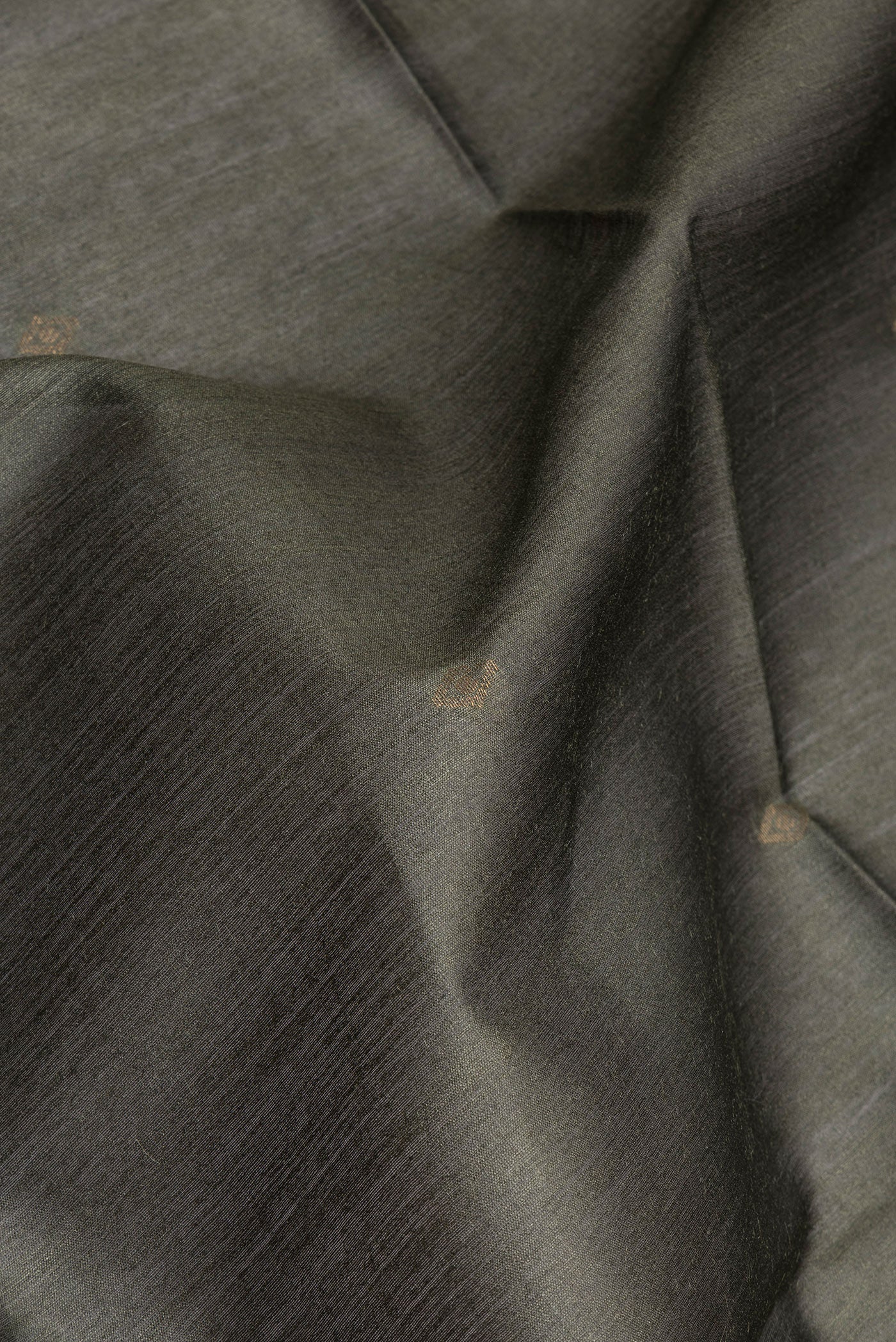 Close up of Mehandi Green Tussar Silk Saree with Zari Butta on the body and Ikat Border.  displaying folds