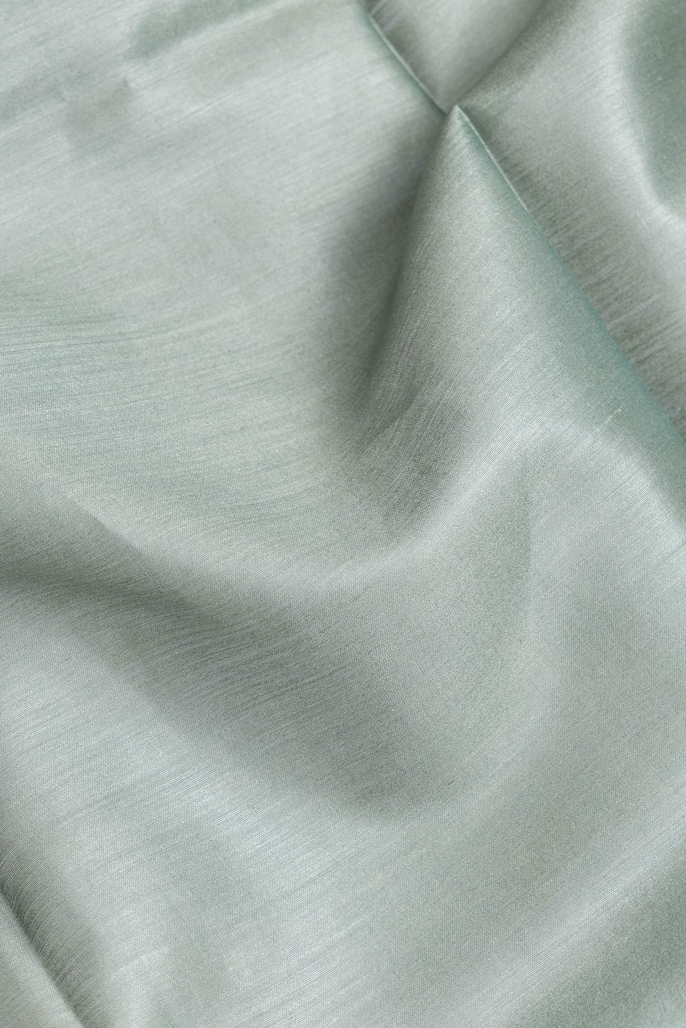 Close up of Green Dual Tone Tussar Silk Saree with Plain Body and Fancy Border.  displaying folds
