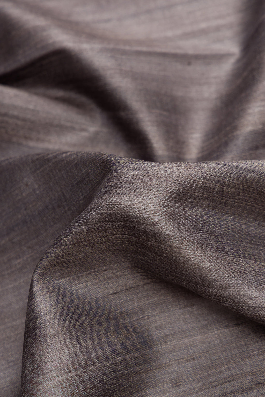 Close up of Grey Dual Tone Tussar Silk Saree with Plain Body and Temple Border.  displaying folds