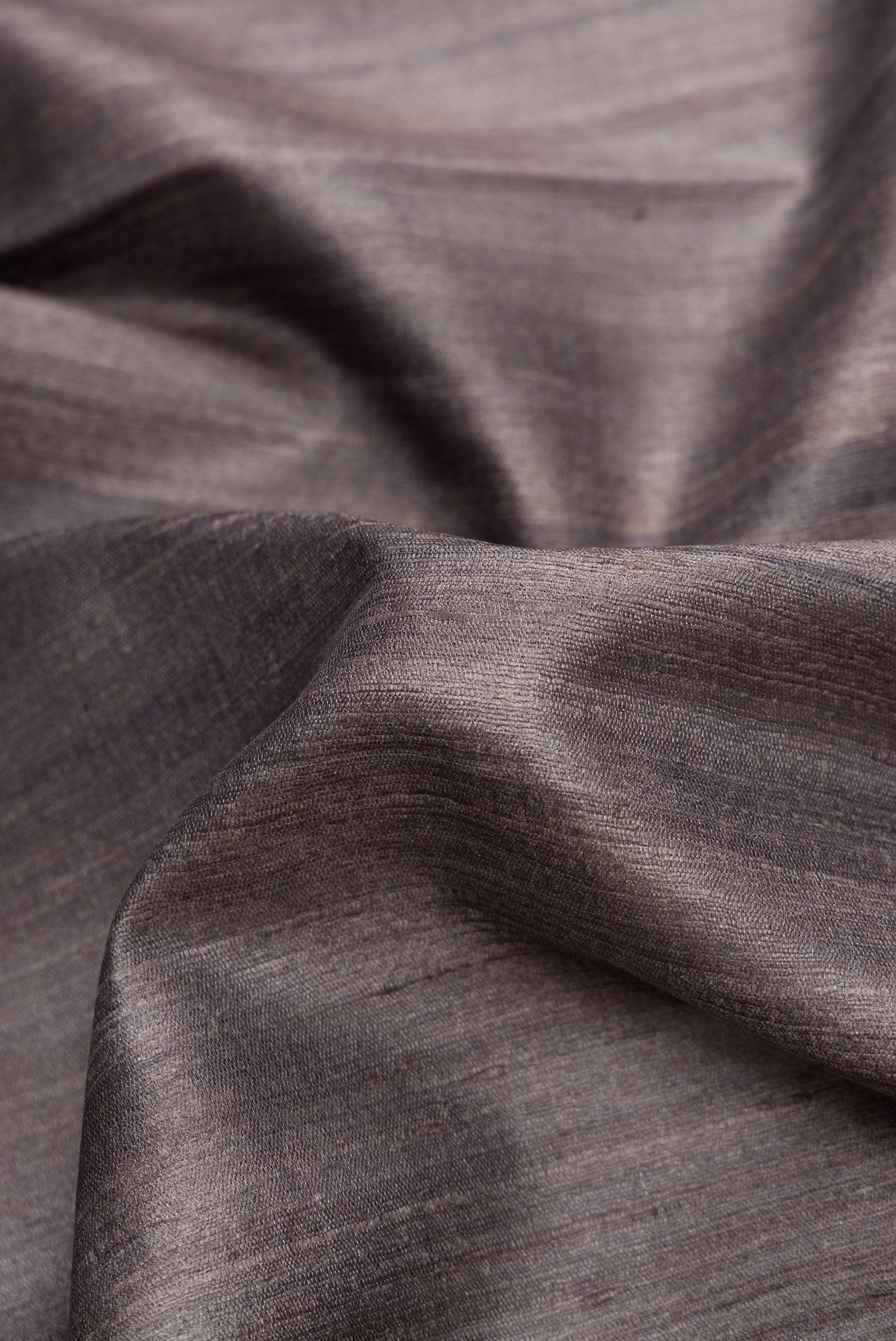 Close up of Grey Dual Tone Tussar Silk Saree with Plain Body and Temple Border.  displaying folds