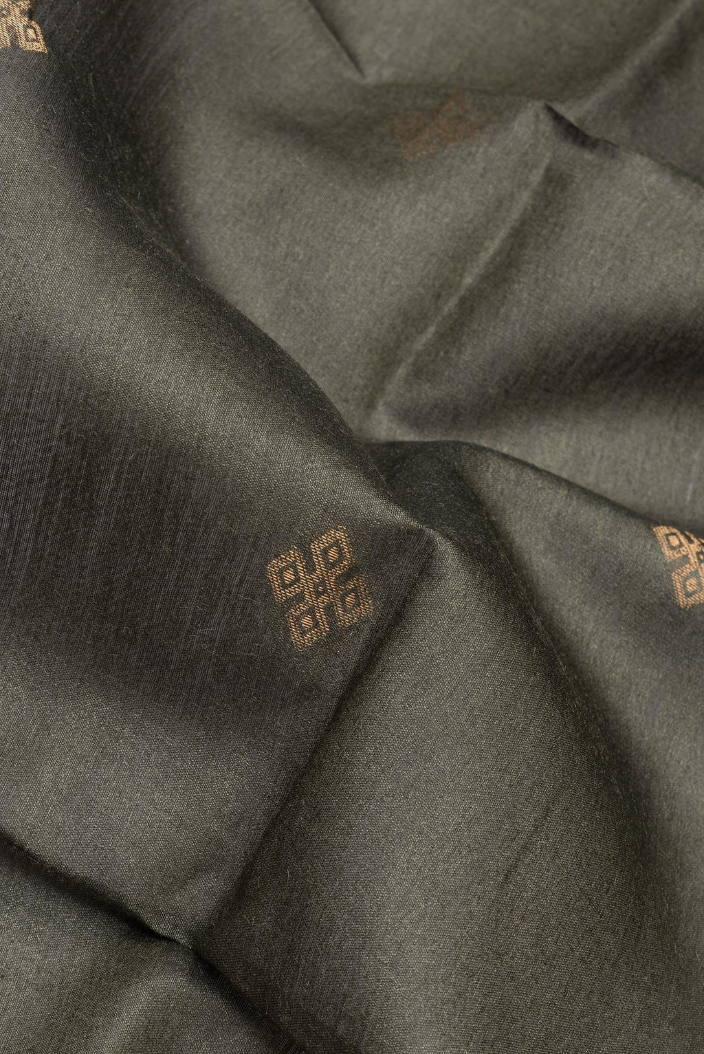Close up of Green Tussar Silk Saree with Zari Butta on the body and Zari Border.  displaying folds