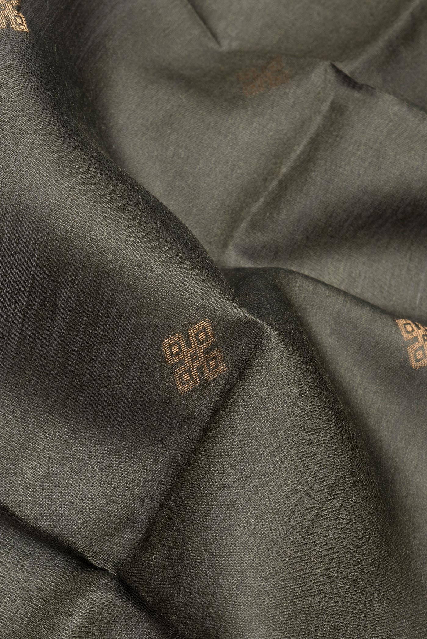 Close up of Green Tussar Silk Saree with Zari Butta on the body and Zari Border.  displaying folds