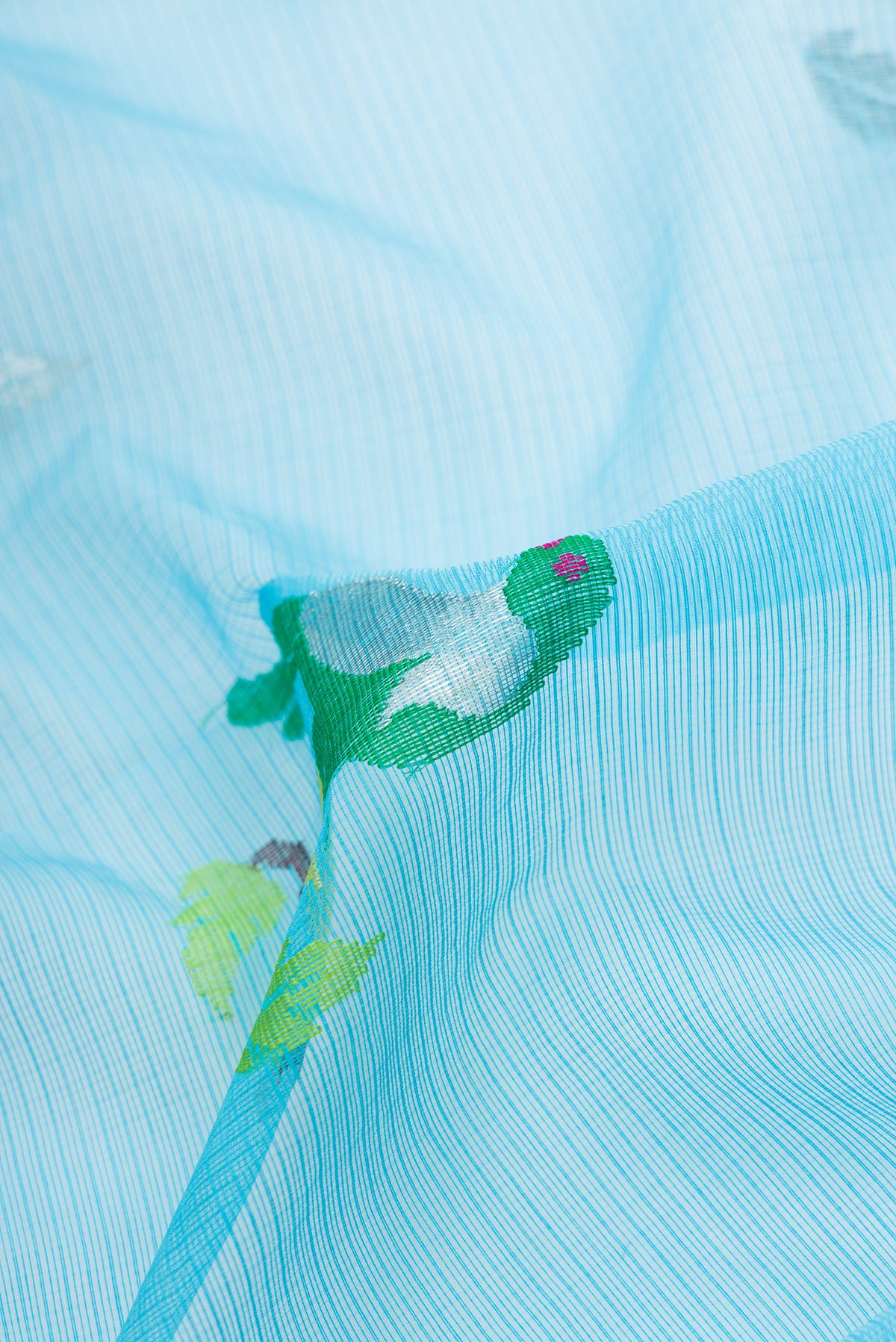 Close up of Sky Blue Dual Tone Kota Silk Saree with Zari And Thread Butta on the body and Zari Border.  displaying folds
