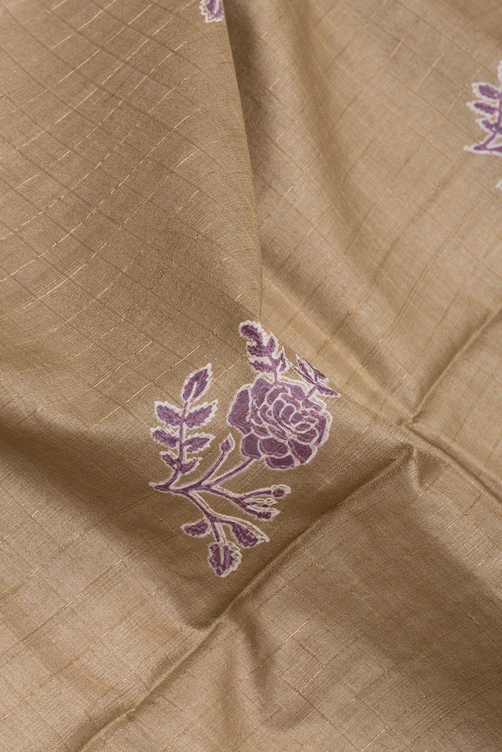 Close up of Dark Beige Tussar Silk Saree with Checked design on the body and Printed Border.  displaying folds