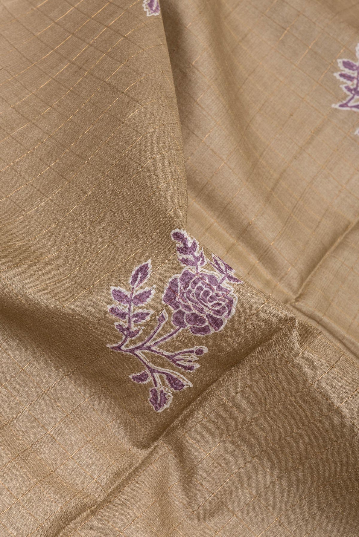 Close up of Dark Beige Tussar Silk Saree with Checked design on the body and Printed Border.  displaying folds