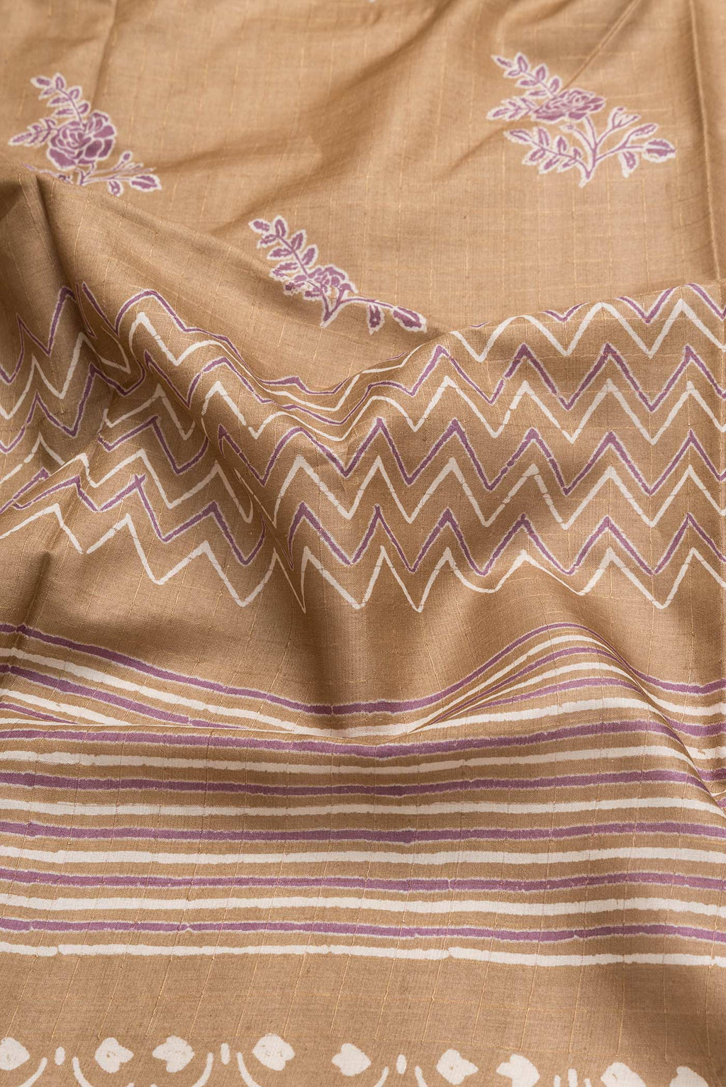 Close up of Caramel Dual Tone Tussar Silk Saree with Printed design on the body and Printed Border.  displaying folds