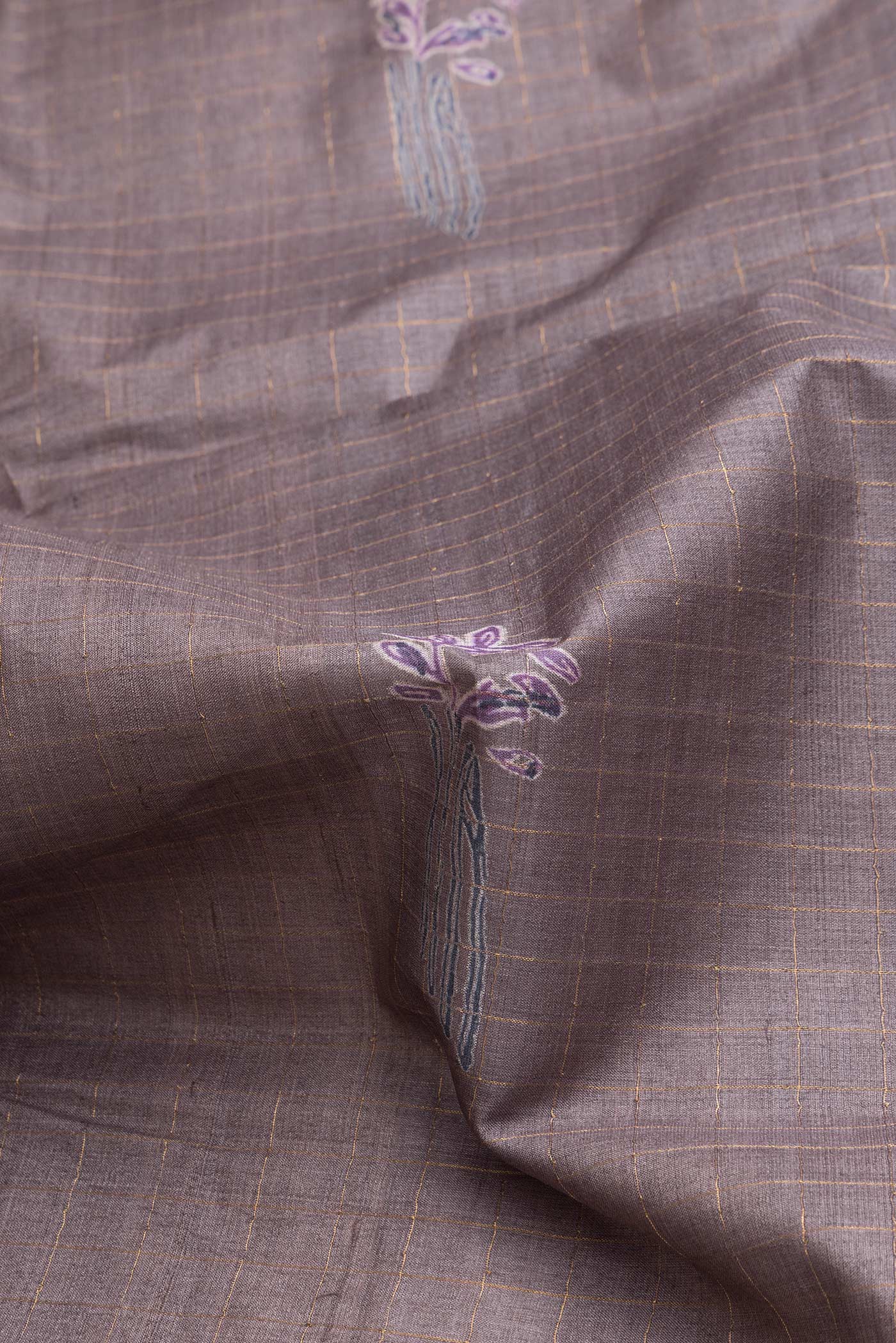 Close up of Grey Dual Tone Tussar Silk Saree with Checked design on the body and Printed Border.  displaying folds