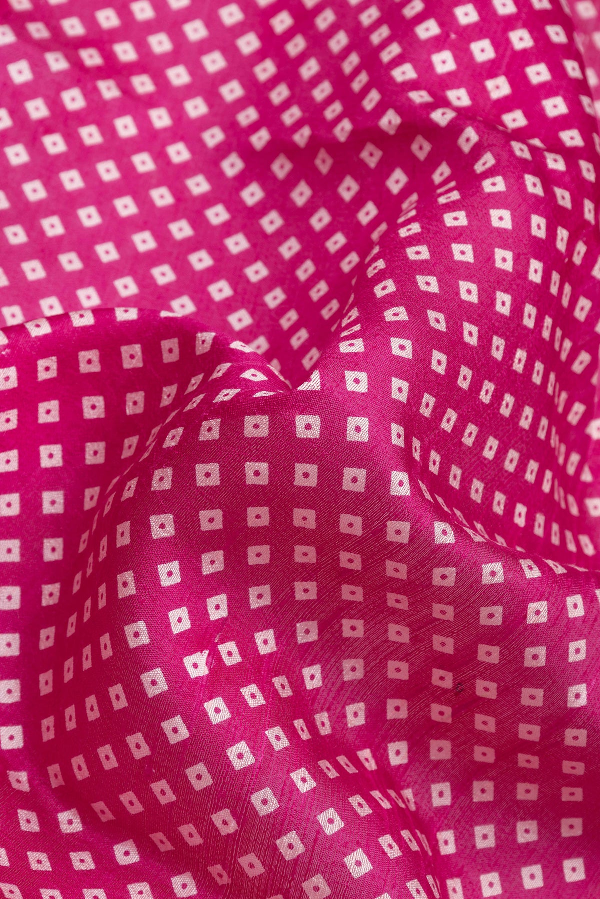Close up of Pink Dual Tone Tussar Silk Saree with Bandhani Print on the body and Zari Border.  displaying folds