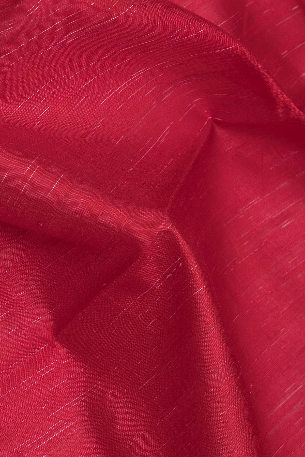 Close up of Red Dual Tone Tussar Silk Saree with Plain Body and Printed Border.  displaying folds