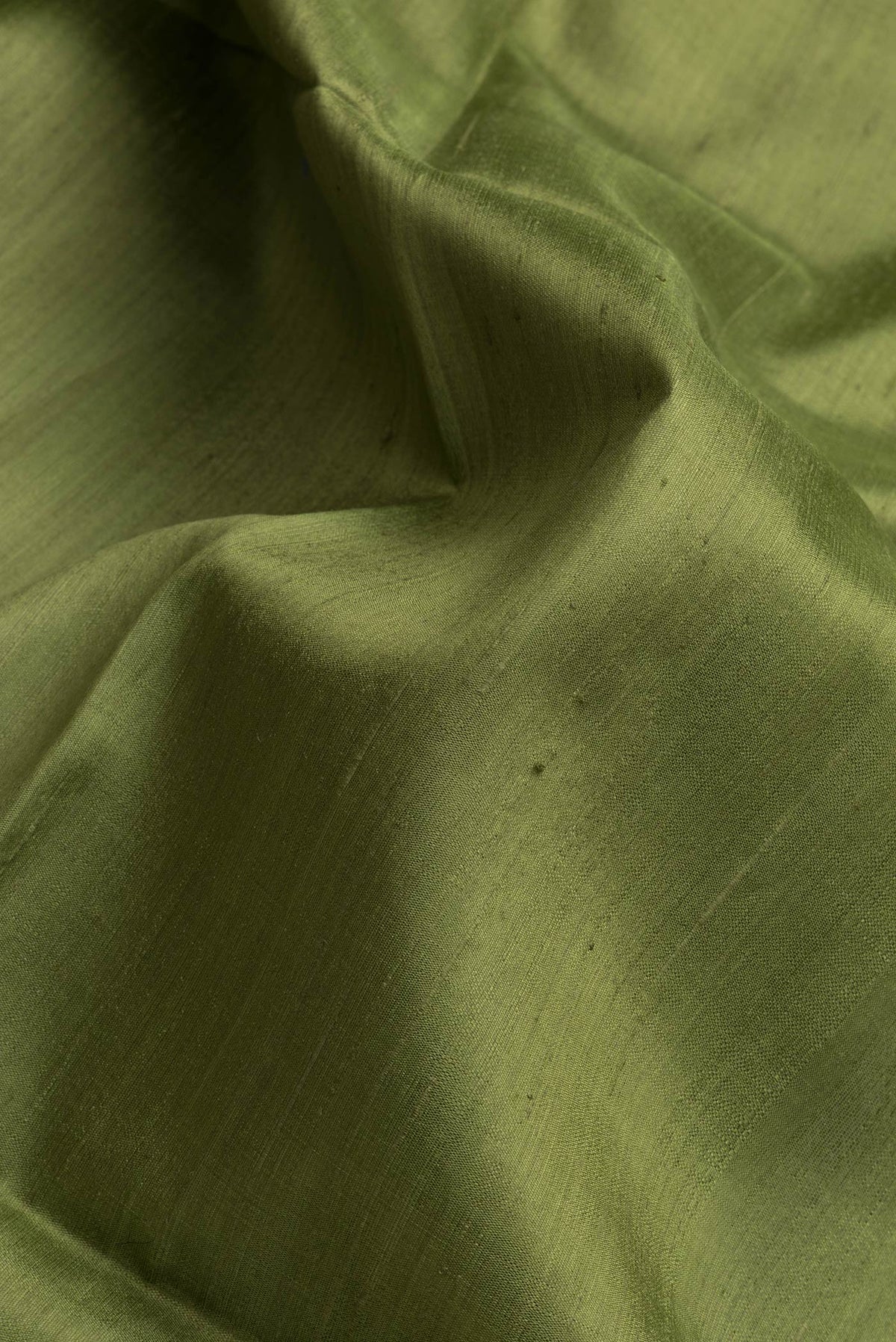Close up of Green Dual Tone Raw Silk Saree with Plain Body and Thin Zari Line.  displaying folds