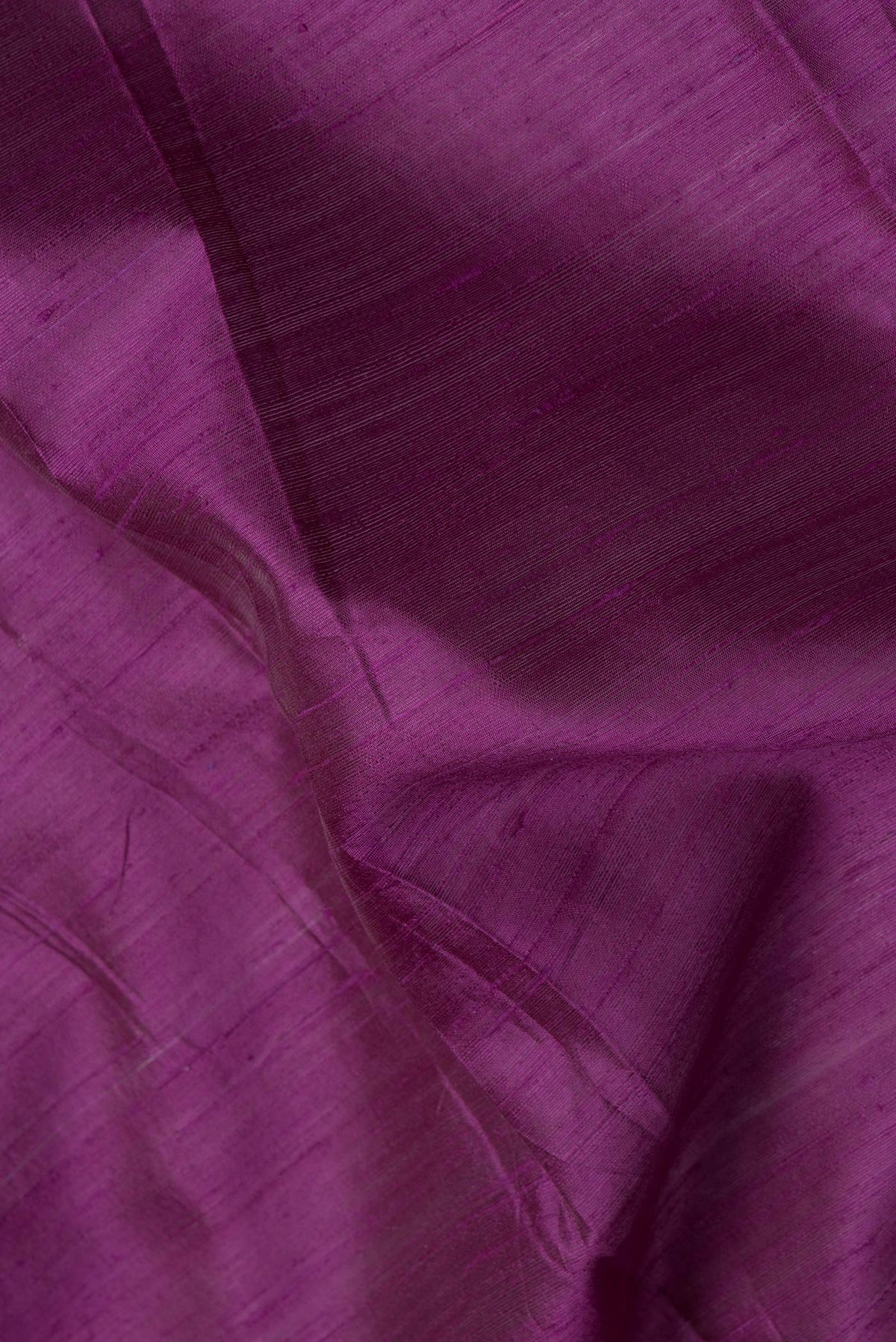 Close up of Violet Dual Tone Raw Silk Saree with Plain Body and Thin Zari Line.  displaying folds