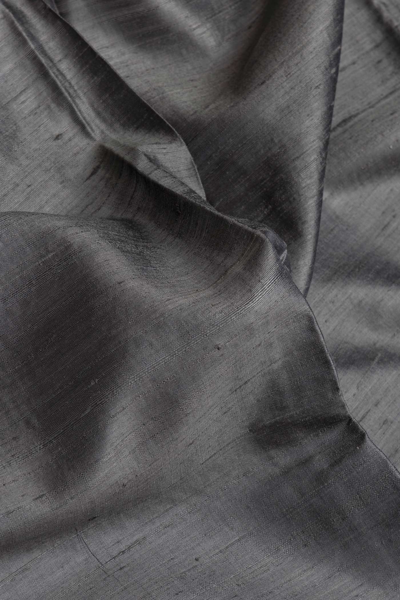 Close up of Grey Dual Tone Raw Silk Saree with Plain Body and Thin Zari Line.  displaying folds