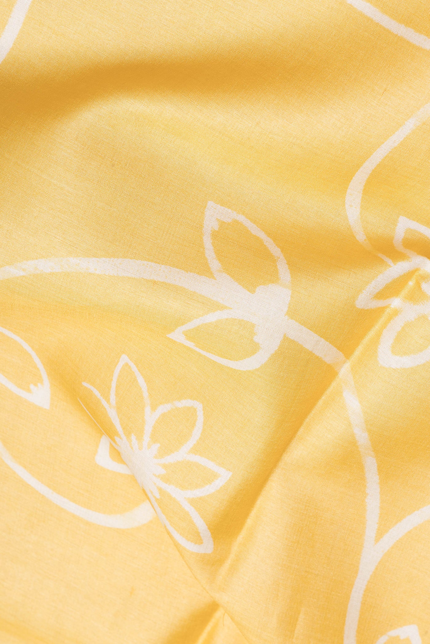 Close up of Yellow Tussar Silk Saree with Printed design on the body and Plain Border.  displaying folds