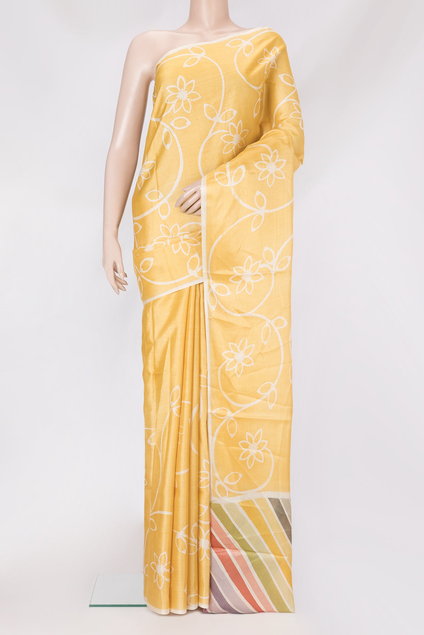Yellow Tussar Silk Saree with Printed design on the body and Plain Border.  displayed on a mannequin