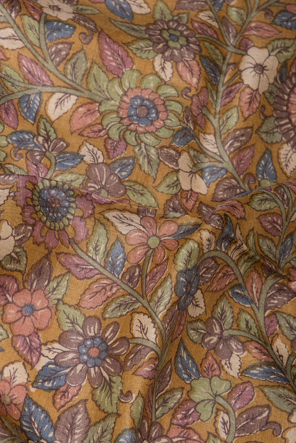 Close up of Pure Silk Mustard Tussar Saree with Printed design on the body and Zari Border.  displaying folds