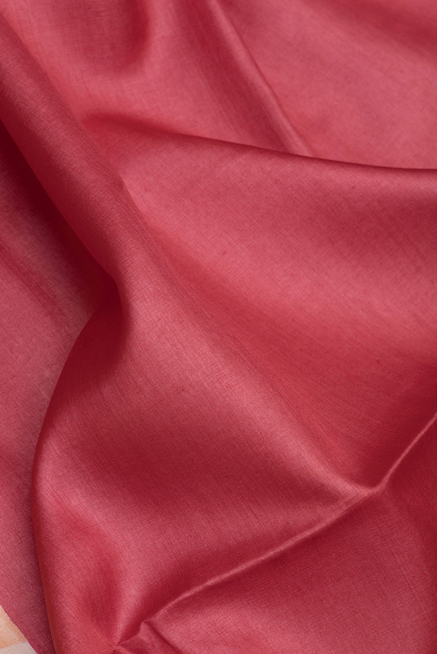 Close up of Red Dual Tone Tussar Silk Saree with Plain Body and Printed Border.  displaying folds