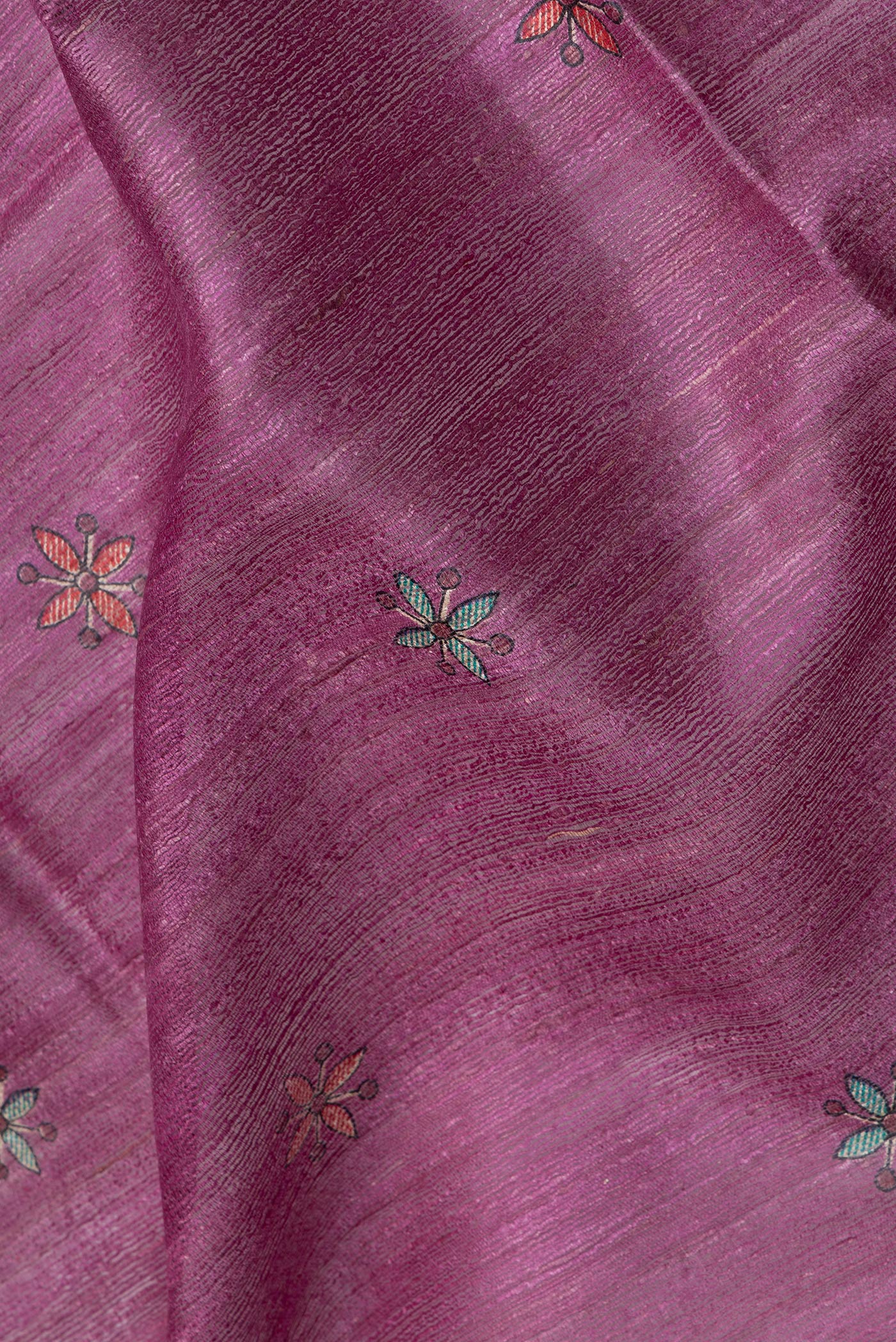 Close up of Magenta Tussar Silk Saree with Printed design on the body and Printed Border.  displaying folds