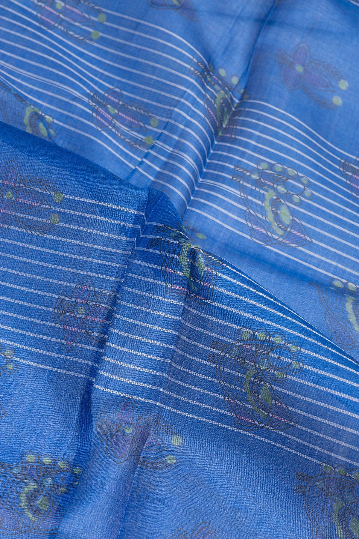 Close up of Peacock Blue Tussar Silk Saree with Printed design on the body and Printed Border.  displaying folds