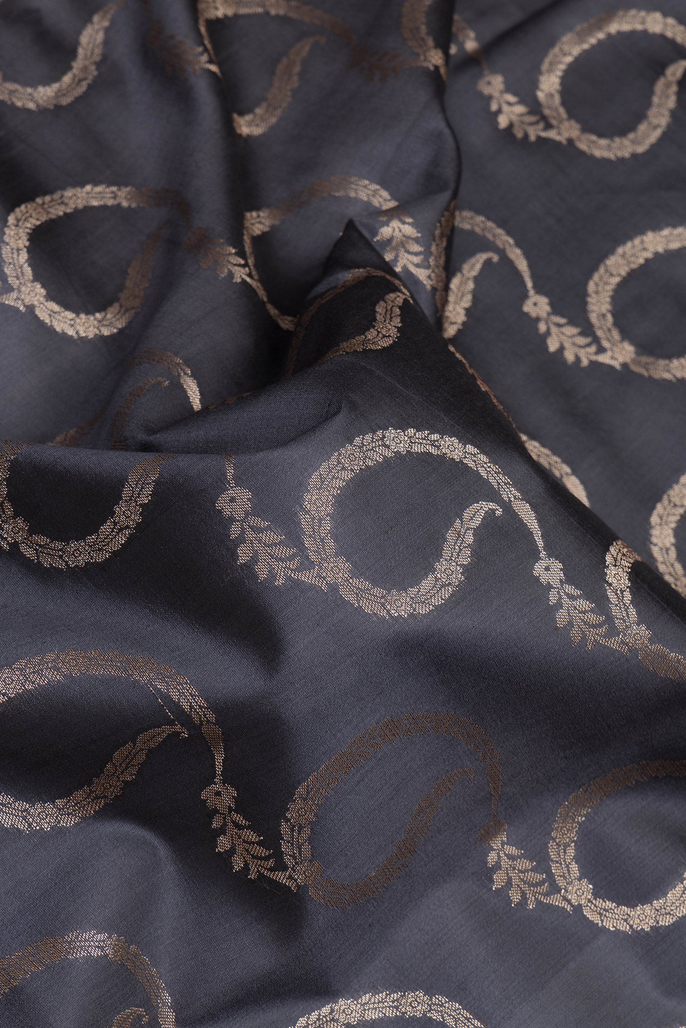 Close up of Grey Dual Tone Tussar Silk Saree with Zari Brocade on the body and Zari Border.  displaying folds
