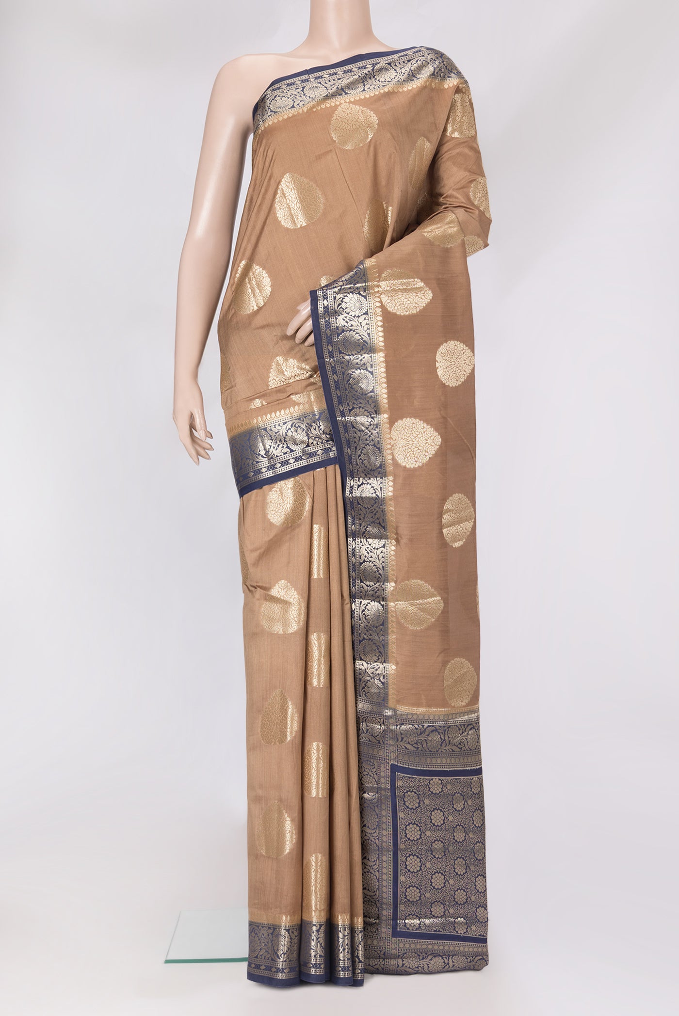 Beige Dual Tone Tussar Silk Saree with Zari Butta on the body and Zari Border.  displayed on a mannequin