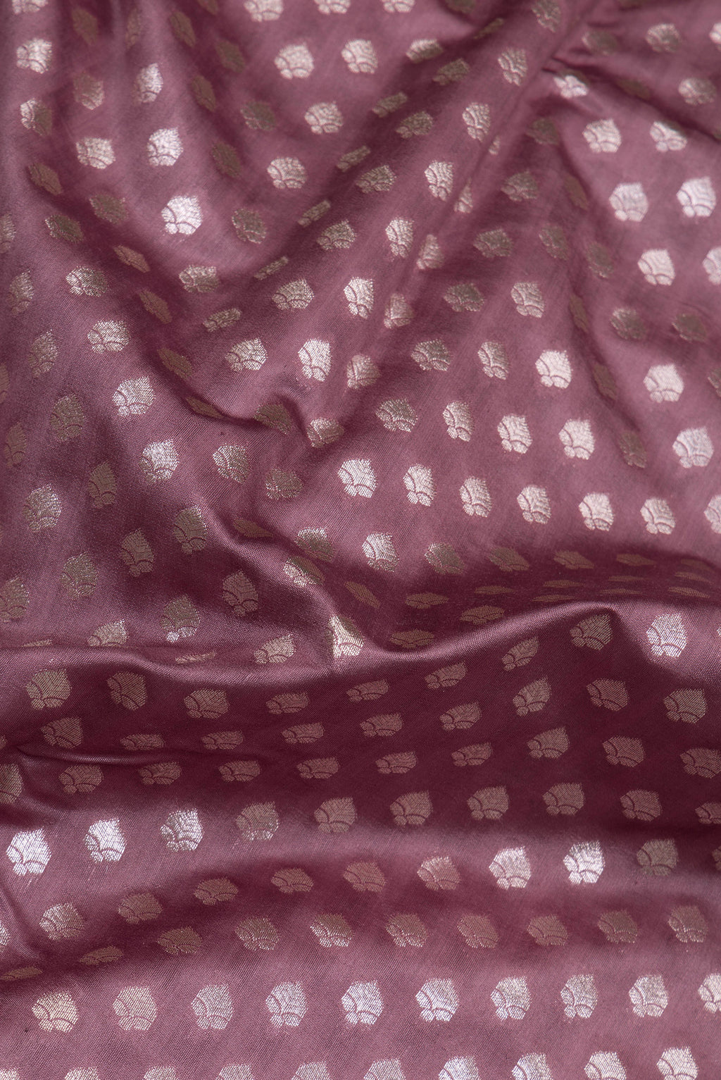 Close up of Mauve Tussar Silk Saree with Zari Butta on the body and Zari Border.  displaying folds