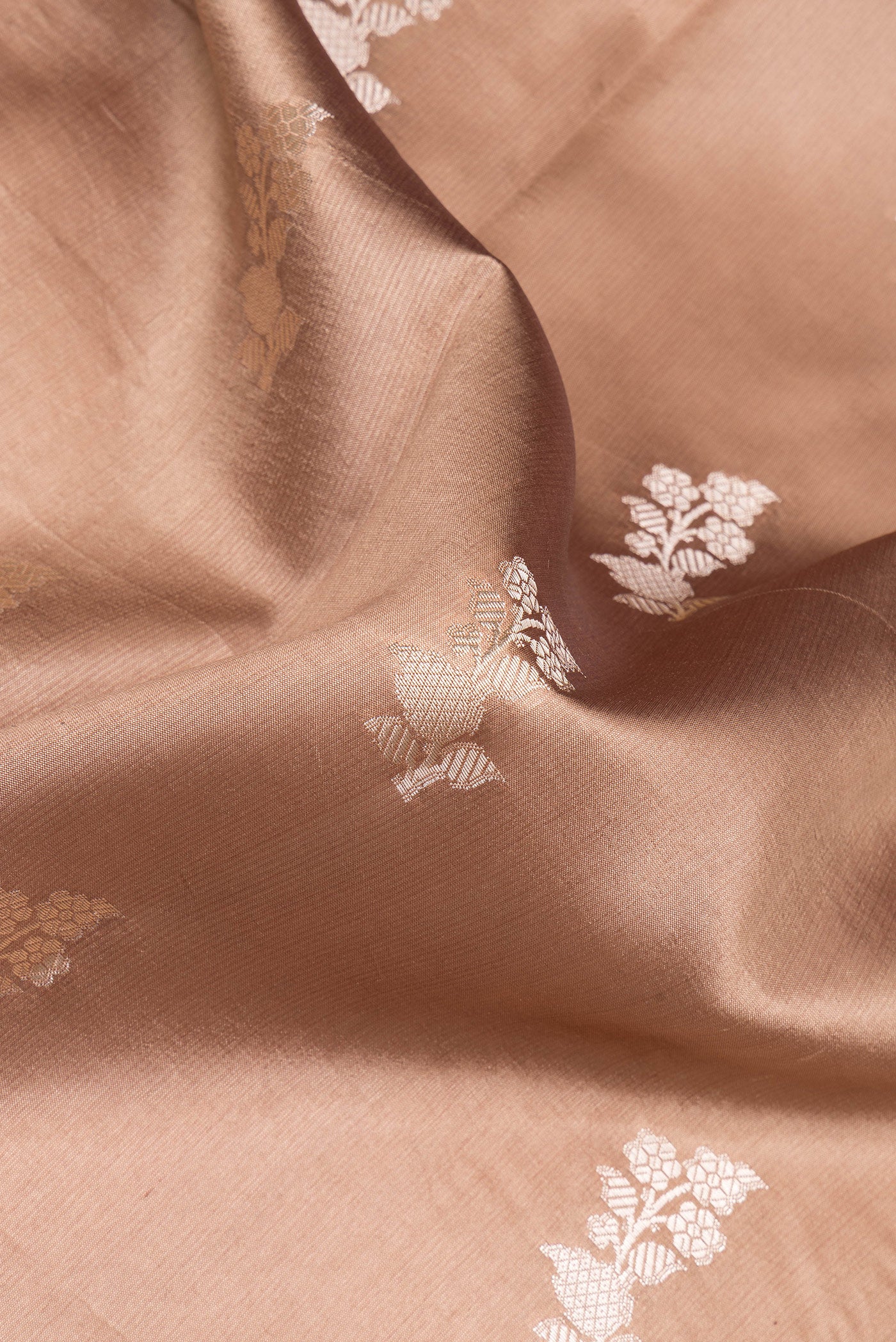 Close up of Brown Tussar Silk Saree with Zari Butta on the body and Zari Border.  displaying folds