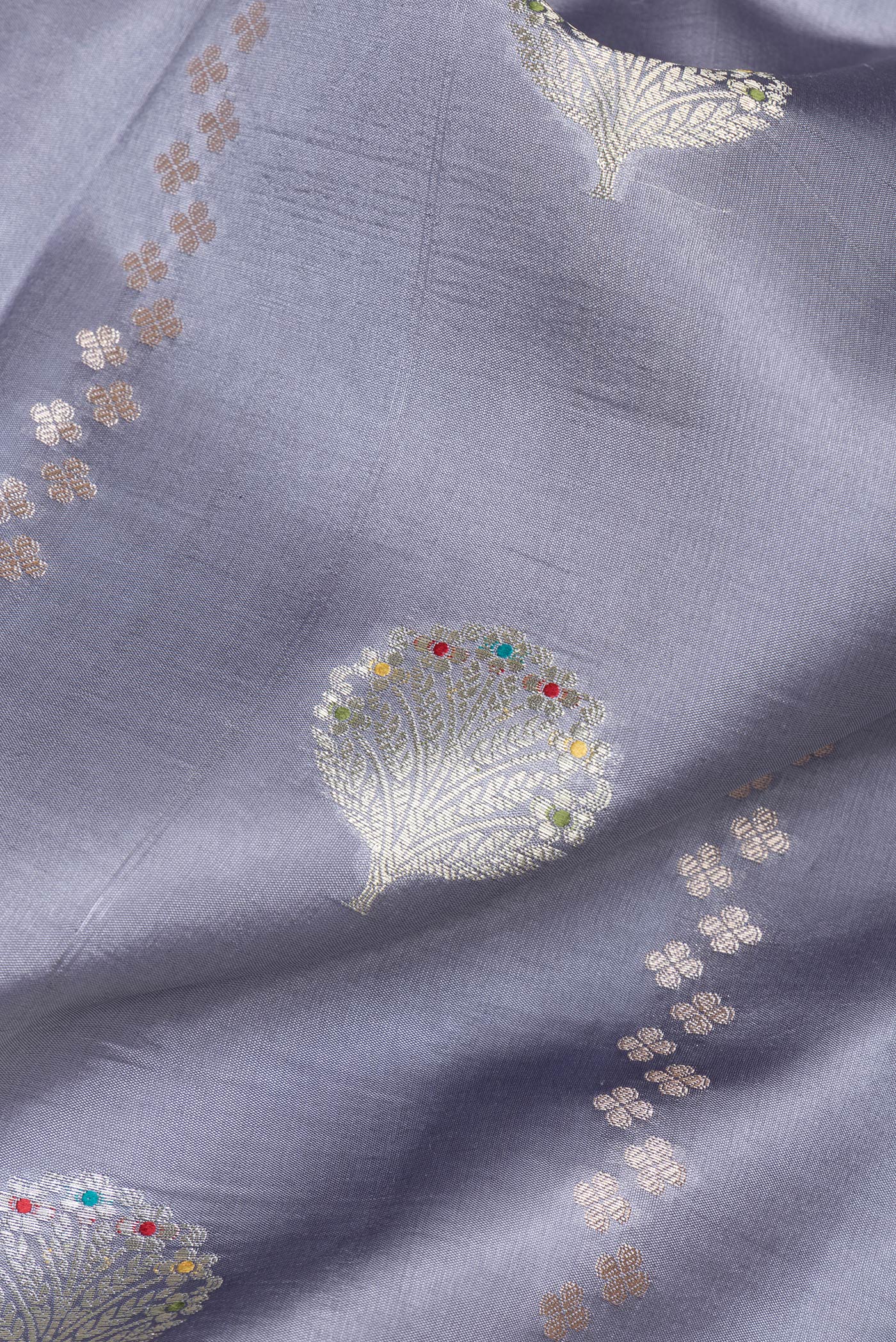 Close up of Grey Dual Tone Tussar Silk Saree with Zari Butta on the body and Fancy Border.  displaying folds