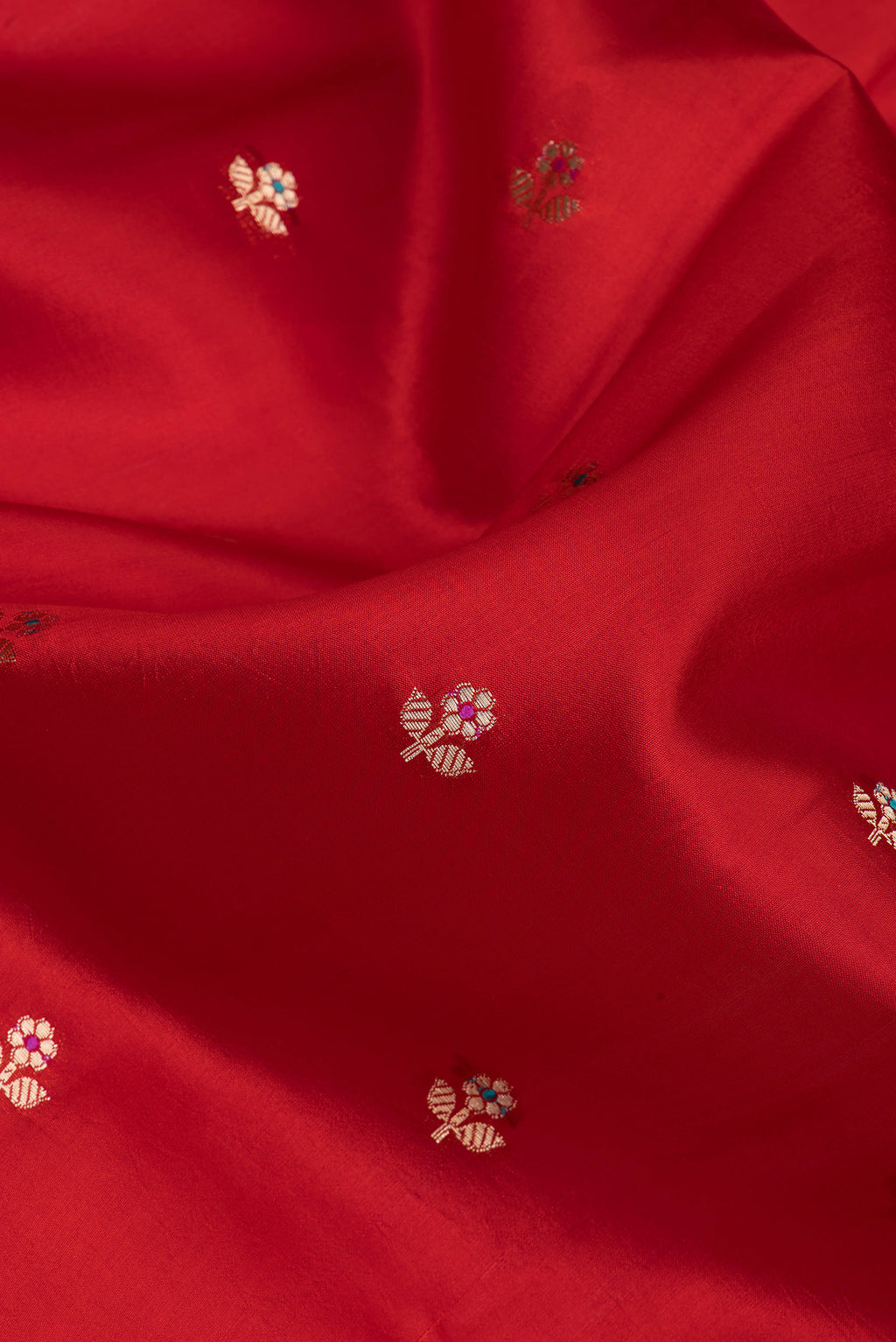 Close up of Red Tussar Silk Saree with Zari Butta on the body and Zari Border.  displaying folds