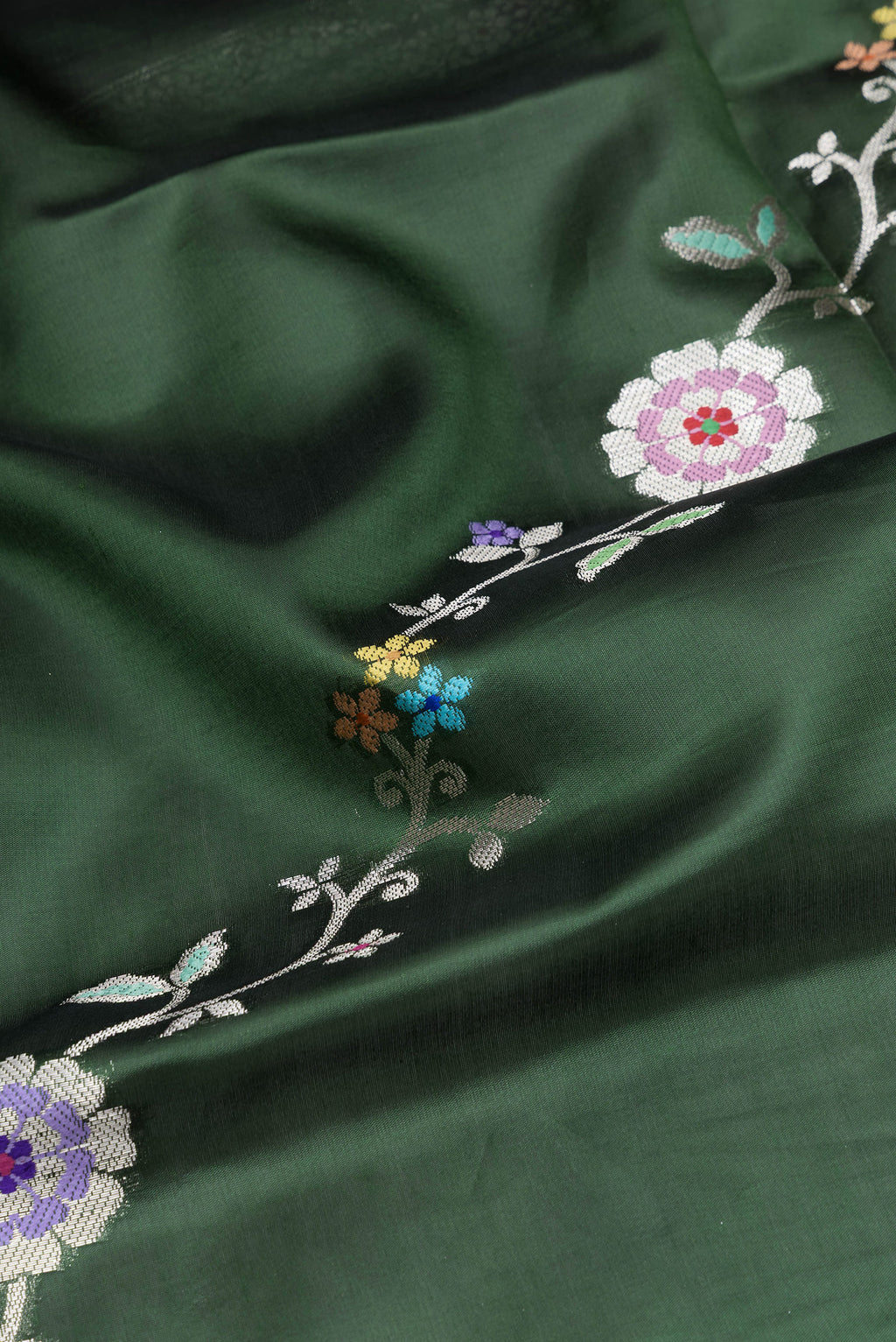 Close up of Bottle Green Tussar Silk Saree with Zari Butta on the body and Fancy Border.  displaying folds