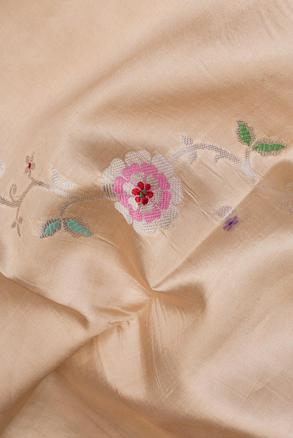 Close up of Beige Tussar Silk Saree with Zari And Thread Butta on the body and Zari Border.  displaying folds