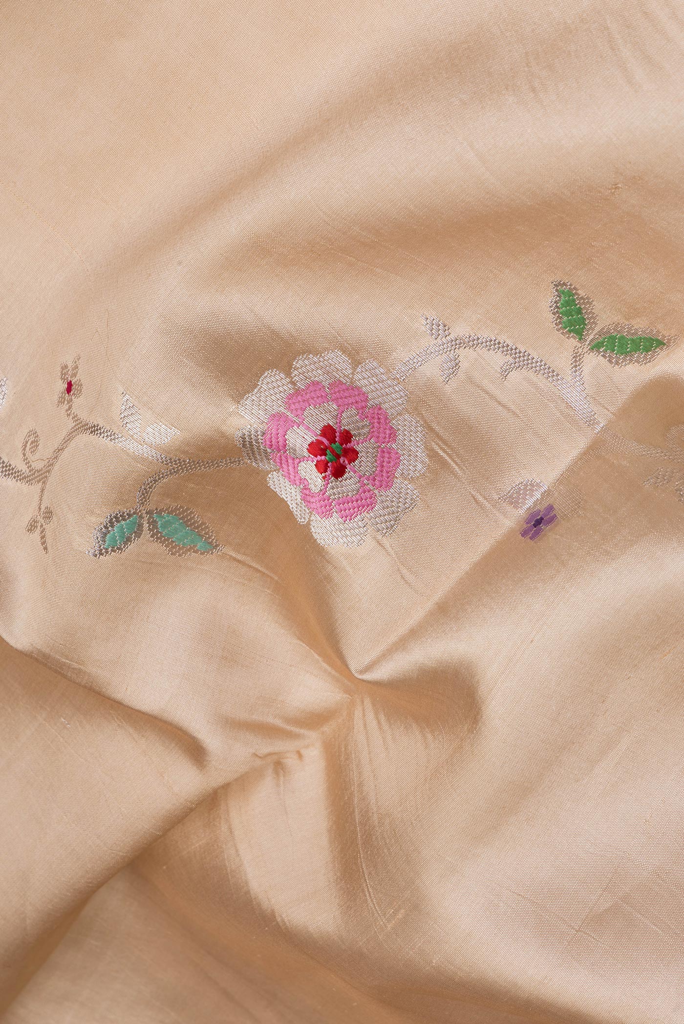 Close up of Beige Tussar Silk Saree with Zari And Thread Butta on the body and Zari Border.  displaying folds
