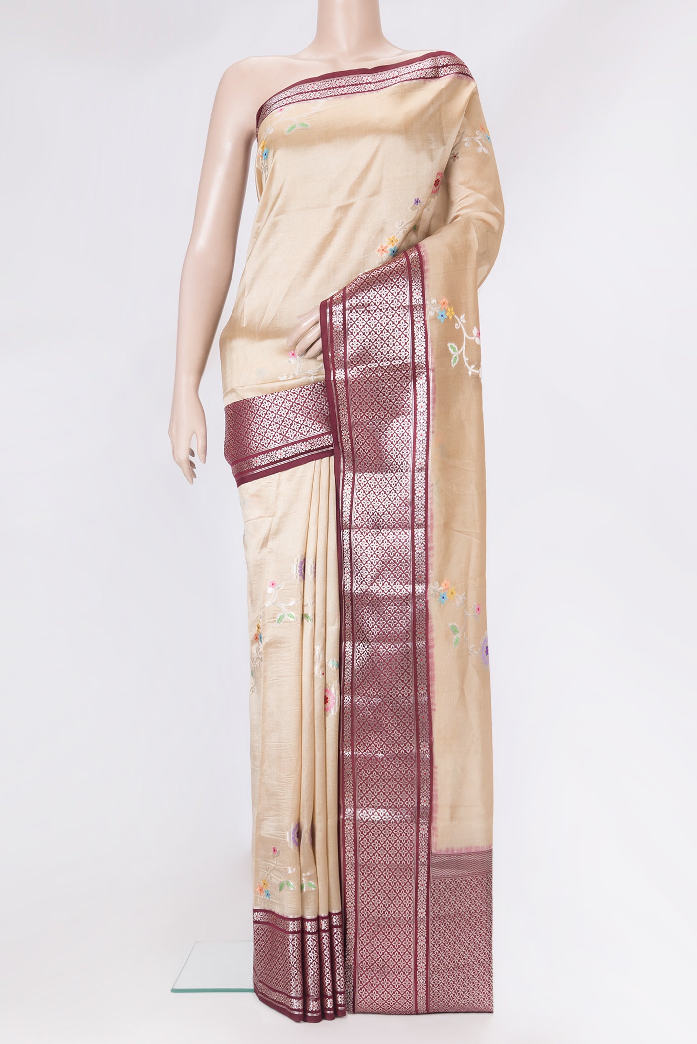 Beige Tussar Silk Saree with Zari And Thread Butta on the body and Zari Border.  displayed on a mannequin