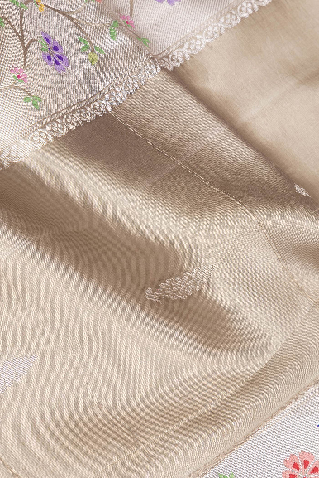Close up of Pure Silk Beige Dual Tone Tussar Saree with Zari Butta on the body and Fancy Border.  displaying folds