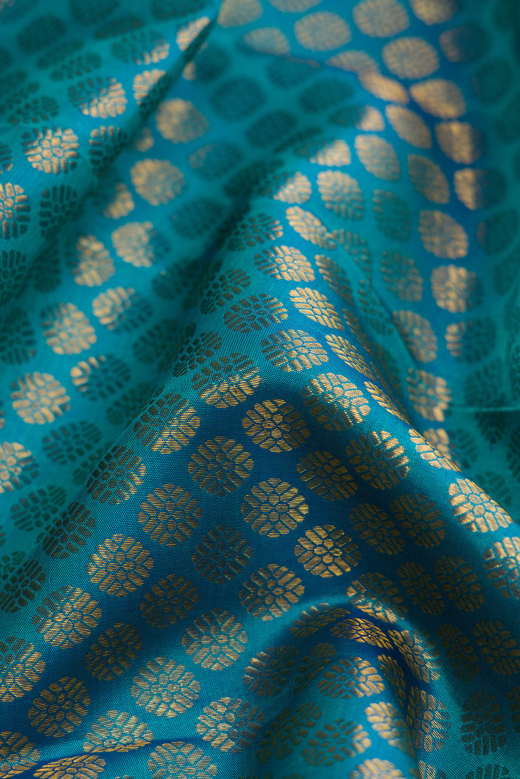 Close up of Peacock Blue Dual Tone Kanchipuram Silk Saree with Zari Brocade on the body and Zari Border.  displaying folds