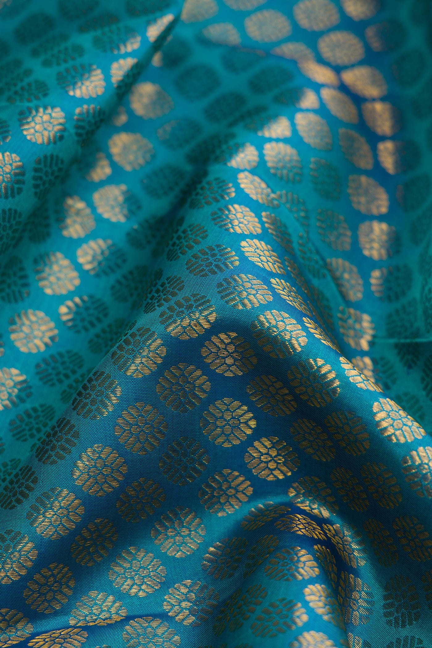 Close up of Peacock Blue Dual Tone Kanchipuram Silk Saree with Zari Brocade on the body and Zari Border.  displaying folds