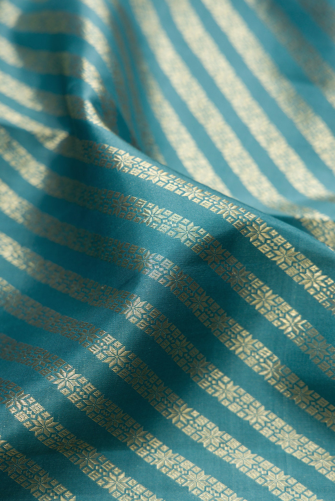 Close up of Maya Blue Kanchipuram Silk Saree with Zari Brocade on the body and Zari Border.  displaying folds