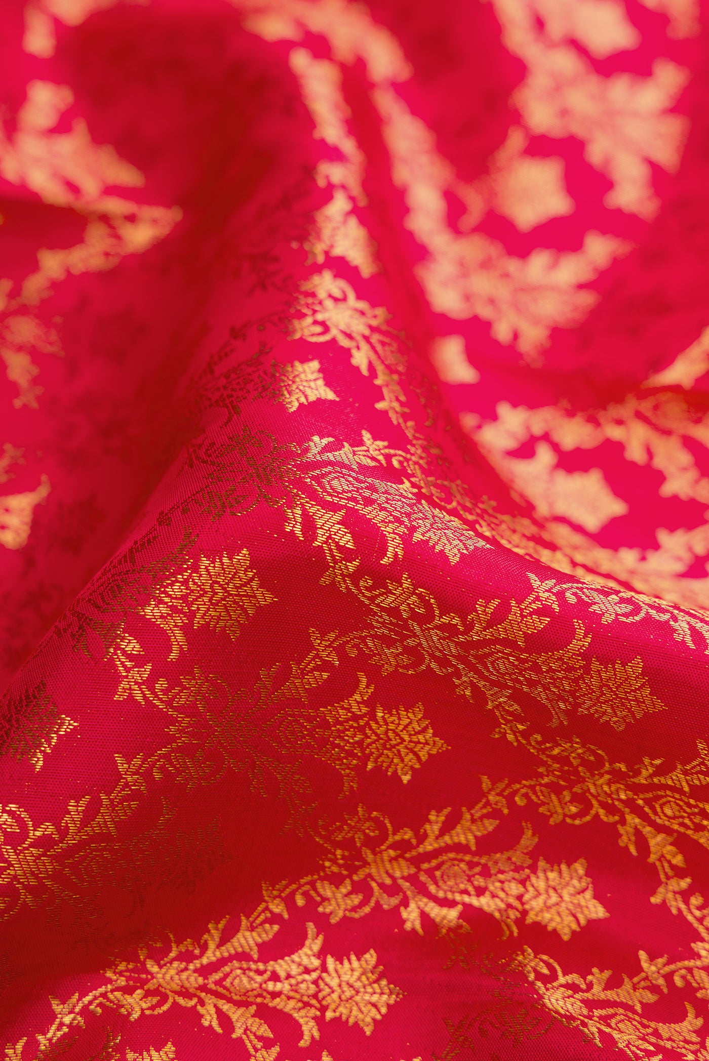 Close up of Dark Pink Dual Tone Kanchipuram Silk Saree with Zari Brocade on the body and Zari Border.  displaying folds